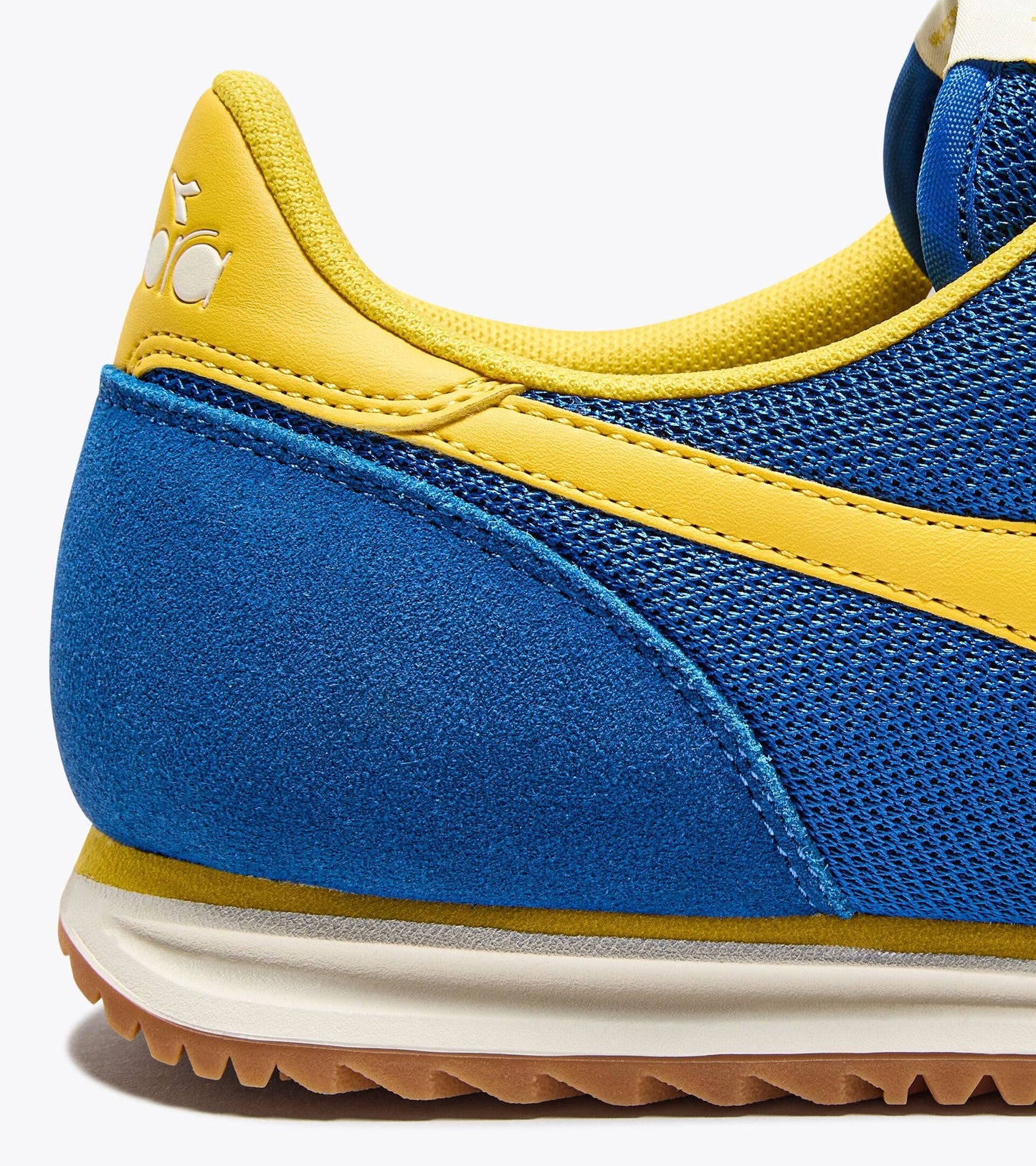 Zoom sur le talon des baskets Cross de Diadora. Détail du logo embossé et couture renforcée.