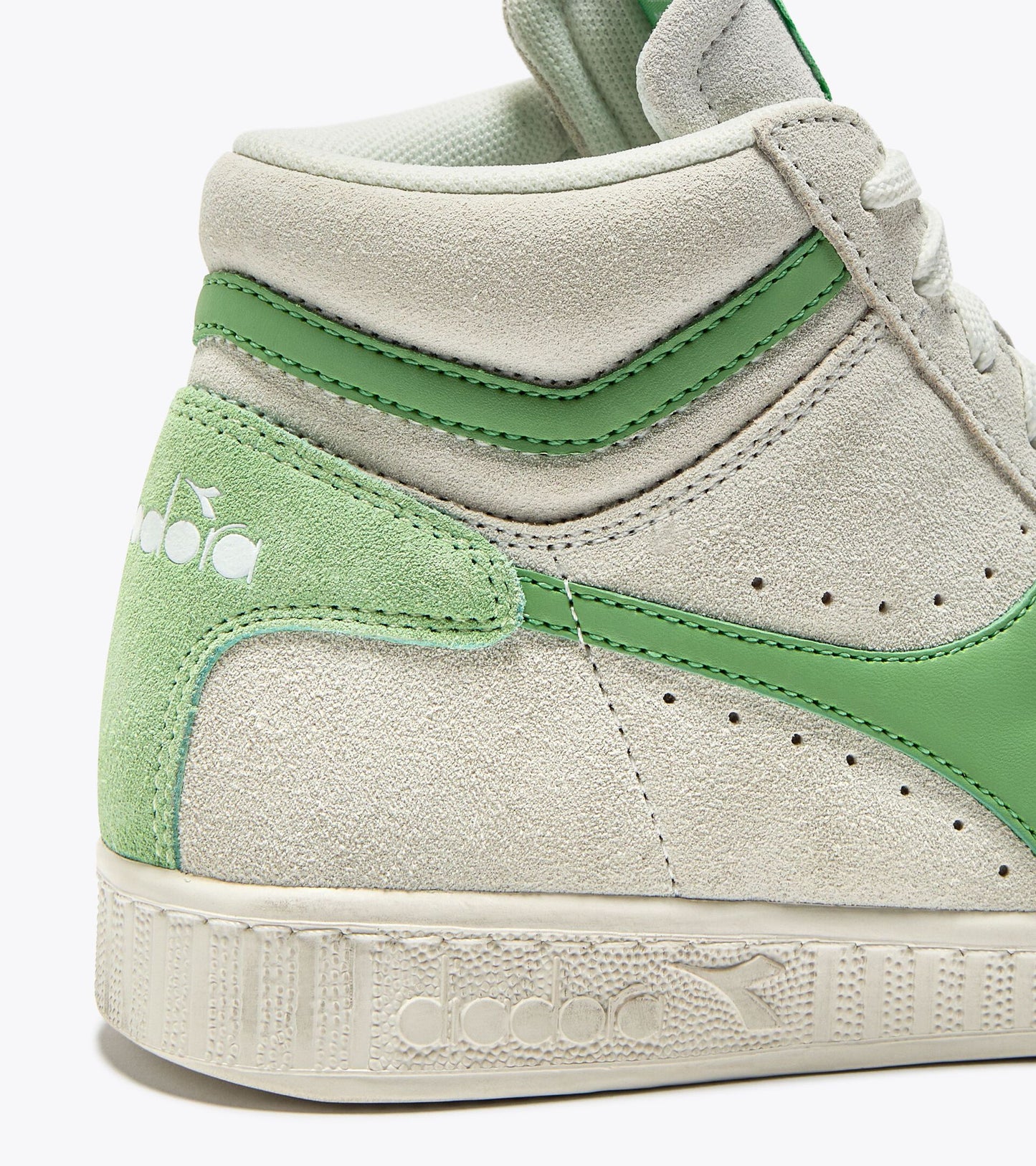 Détail du talon de la basket Game L Suede Diadora. Contrefort vert contrastant avec logo embossé.