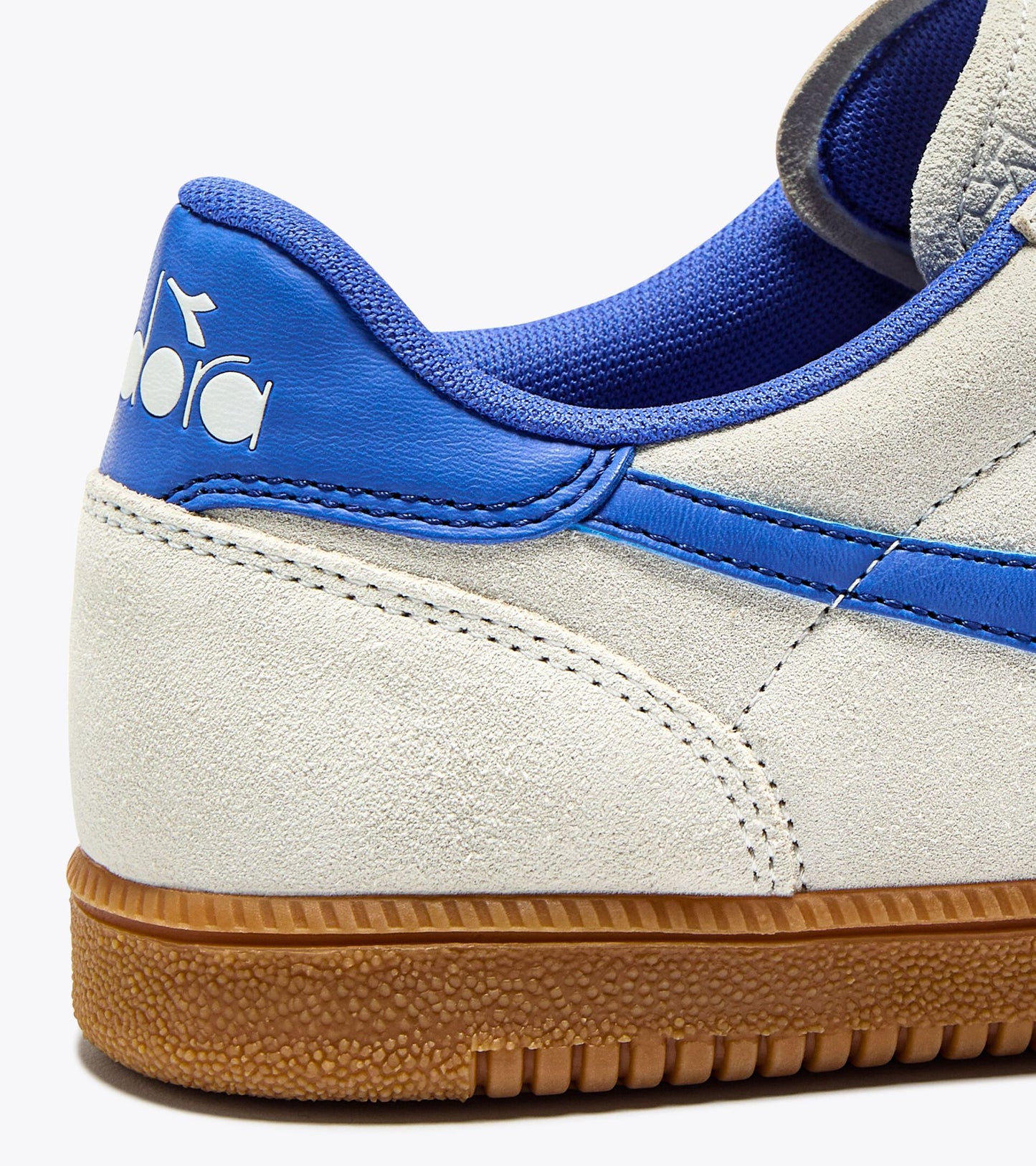 Zoom sur le logo bleu latéral des baskets Tokyo Diadora. Suède texturé et finition cousue.