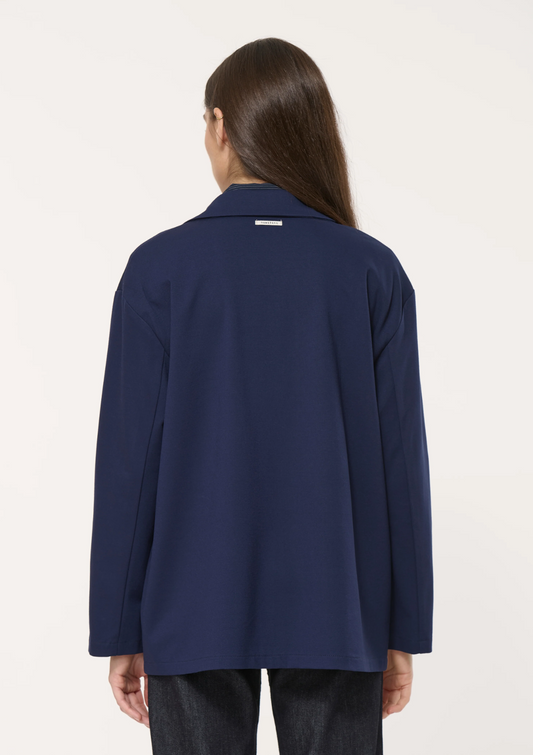 Vue de dos du blazer oversize bleu marine en jersey de chez Humility, montrant sa coupe droite et fluide.