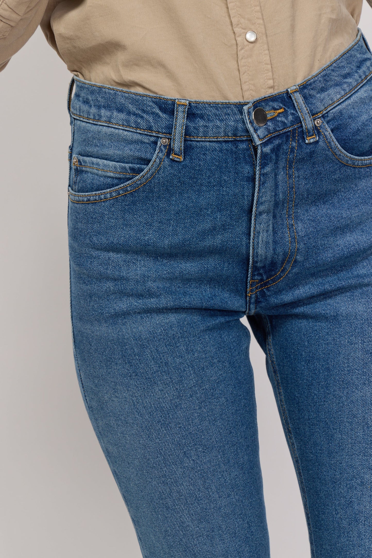Zoom sur le jean Blair de la marque Acquaverde en denim stretch. Détail du bouton et des coutures au niveau de la taille.