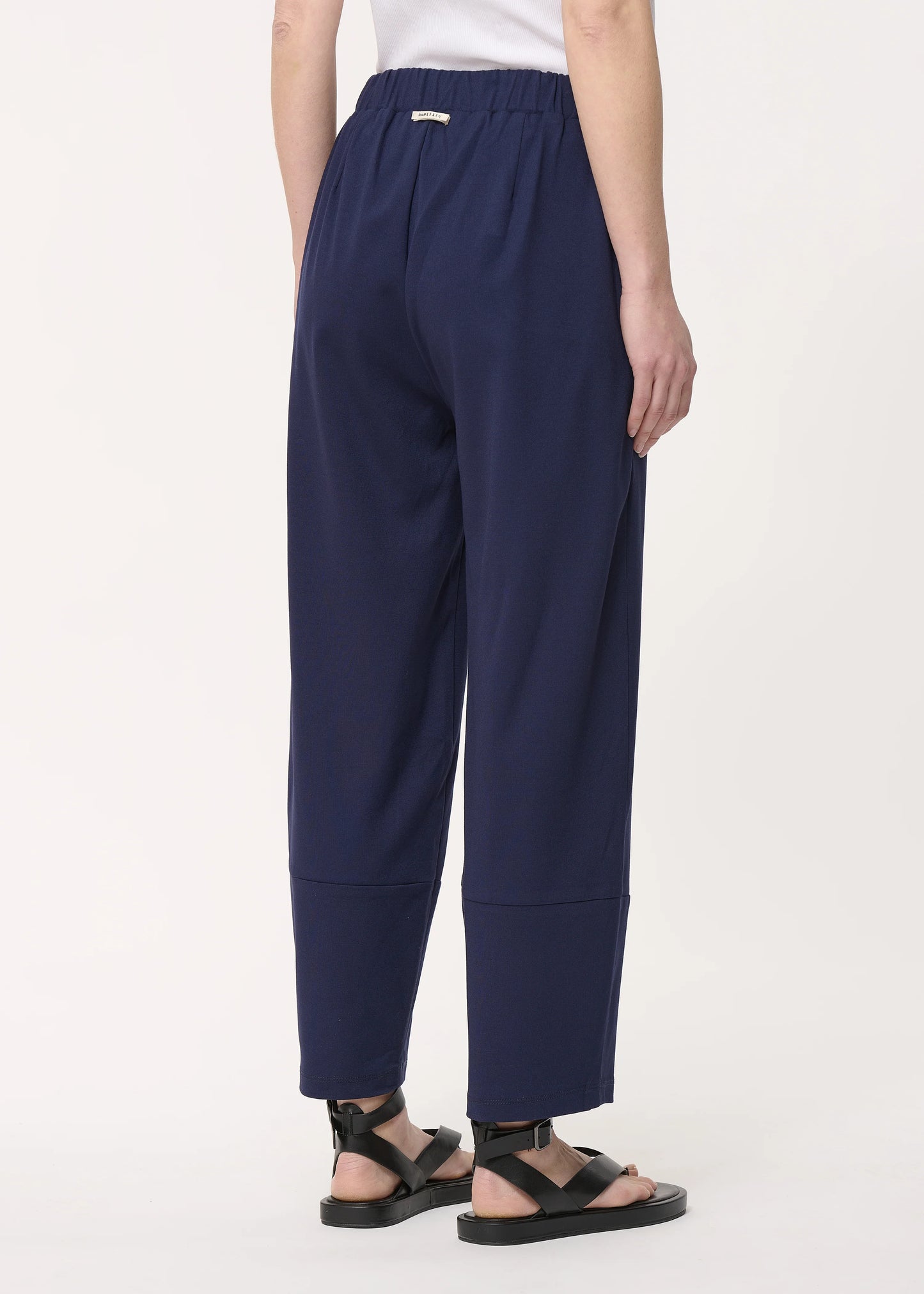 femme portant le pantalon unia bleu marine de chez humility, vue de dos
