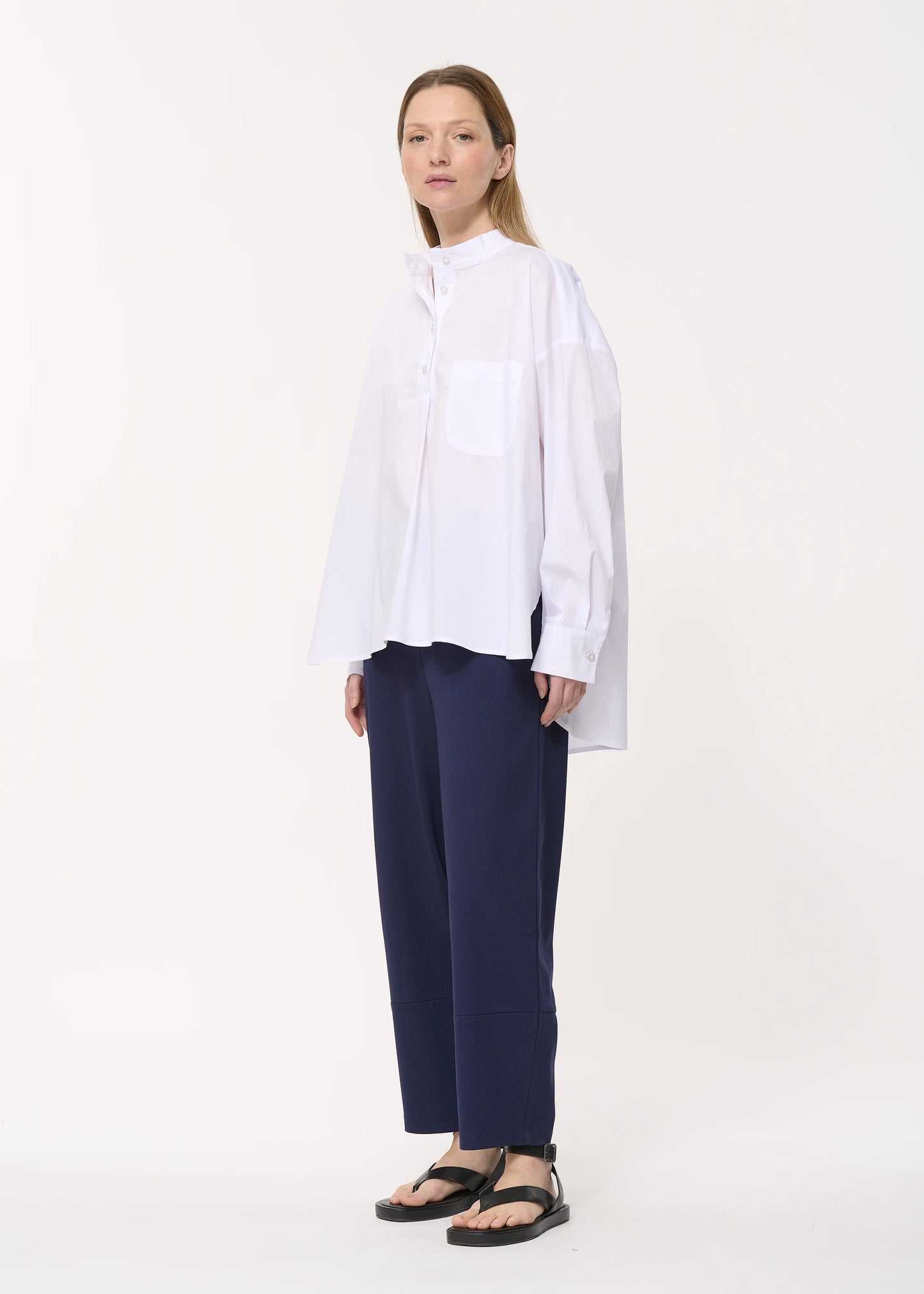femme portant le pantalon unia de chez humility en bleu marine, porté de côté