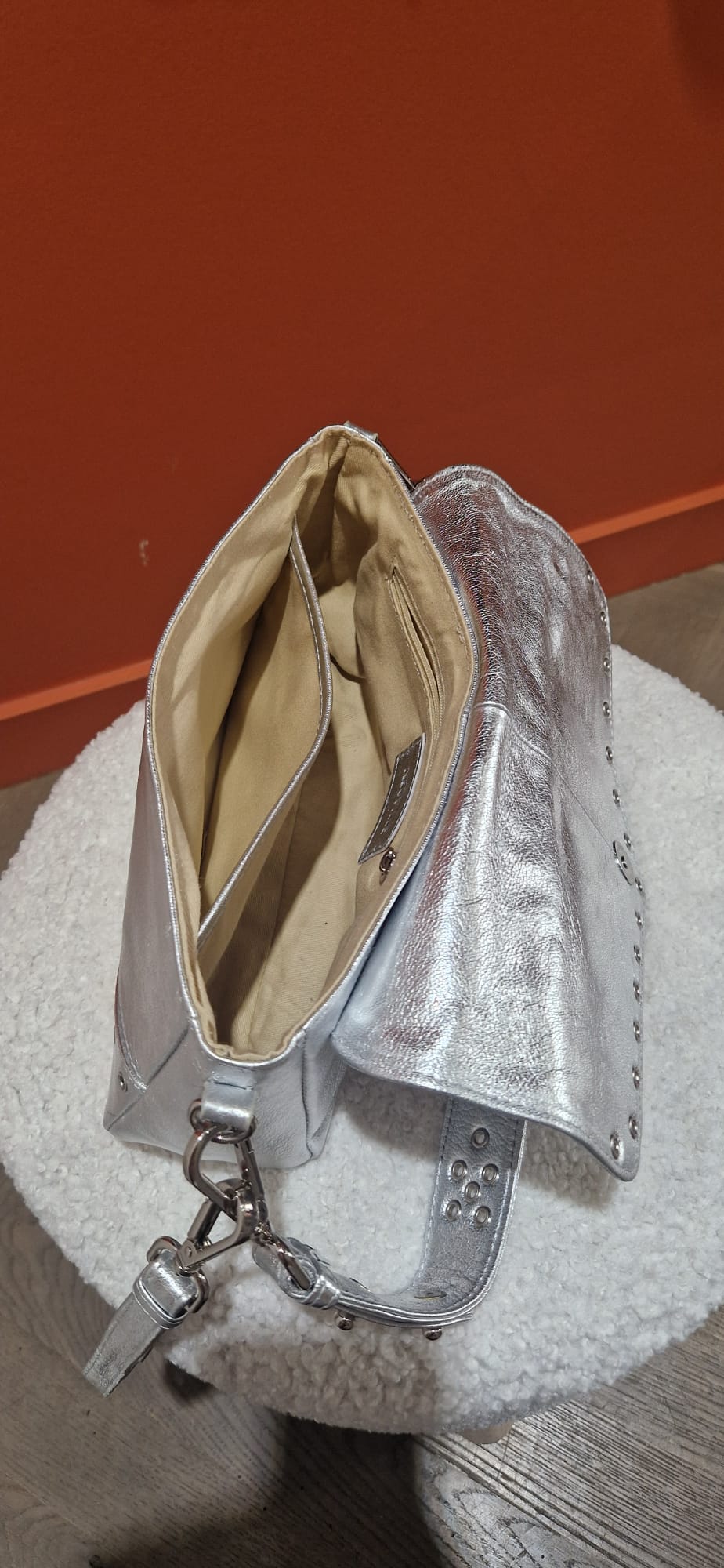 Vue intérieure du sac Serena de la marque Neuville en cuir argenté. Montre la doublure coton beige, les compartiments et la poche zippée.
