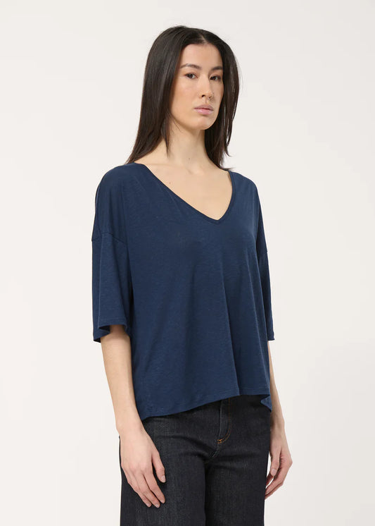 T-shirt Josie Humility manches 3/4 en bleu marine, col en V et coupe fluide, porté avec un pantalon.