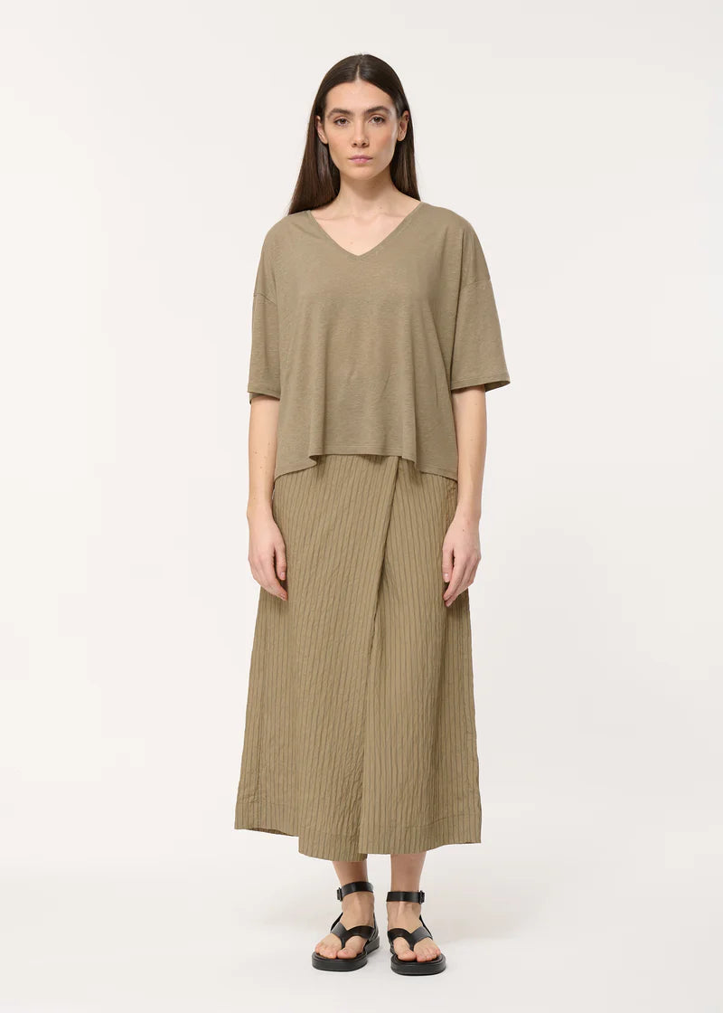 T-shirt Josie de chez Humility manches 3/4 en kaki, coupe ample et col en V, porté avec une jupe longue.