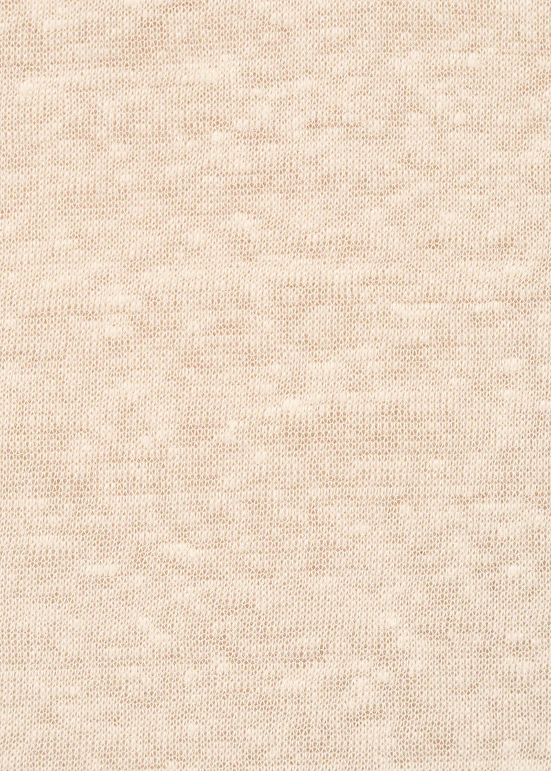 Zoom sur la texture fine et légèrement transparente du tissu beige du t-shirt polo Titane de chez Humility.