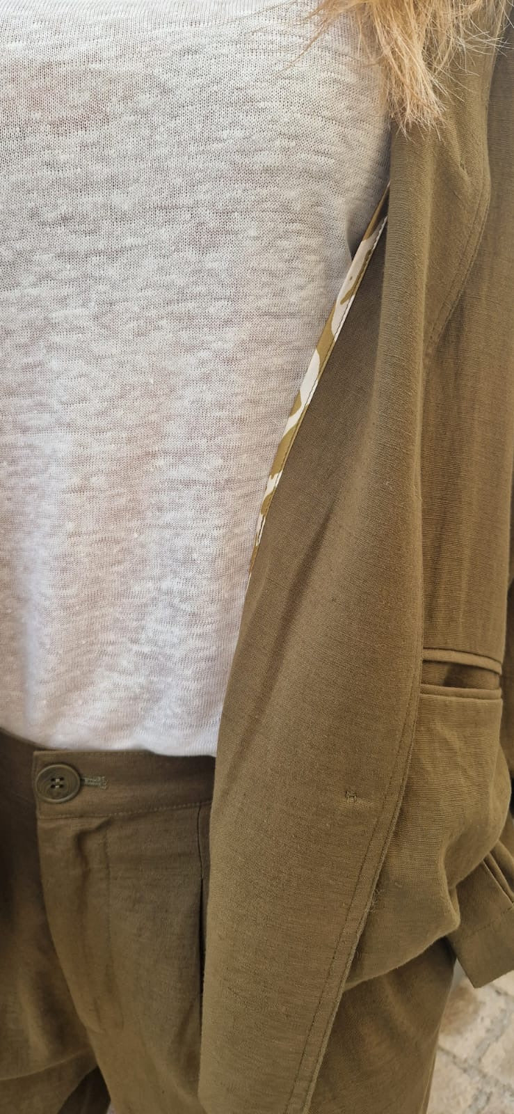 Zoom sur une femme portant la veste marion en kaki de chez Bella Jones. Veste fluide au style décontracté avec détail imprimé à l'intérieur.