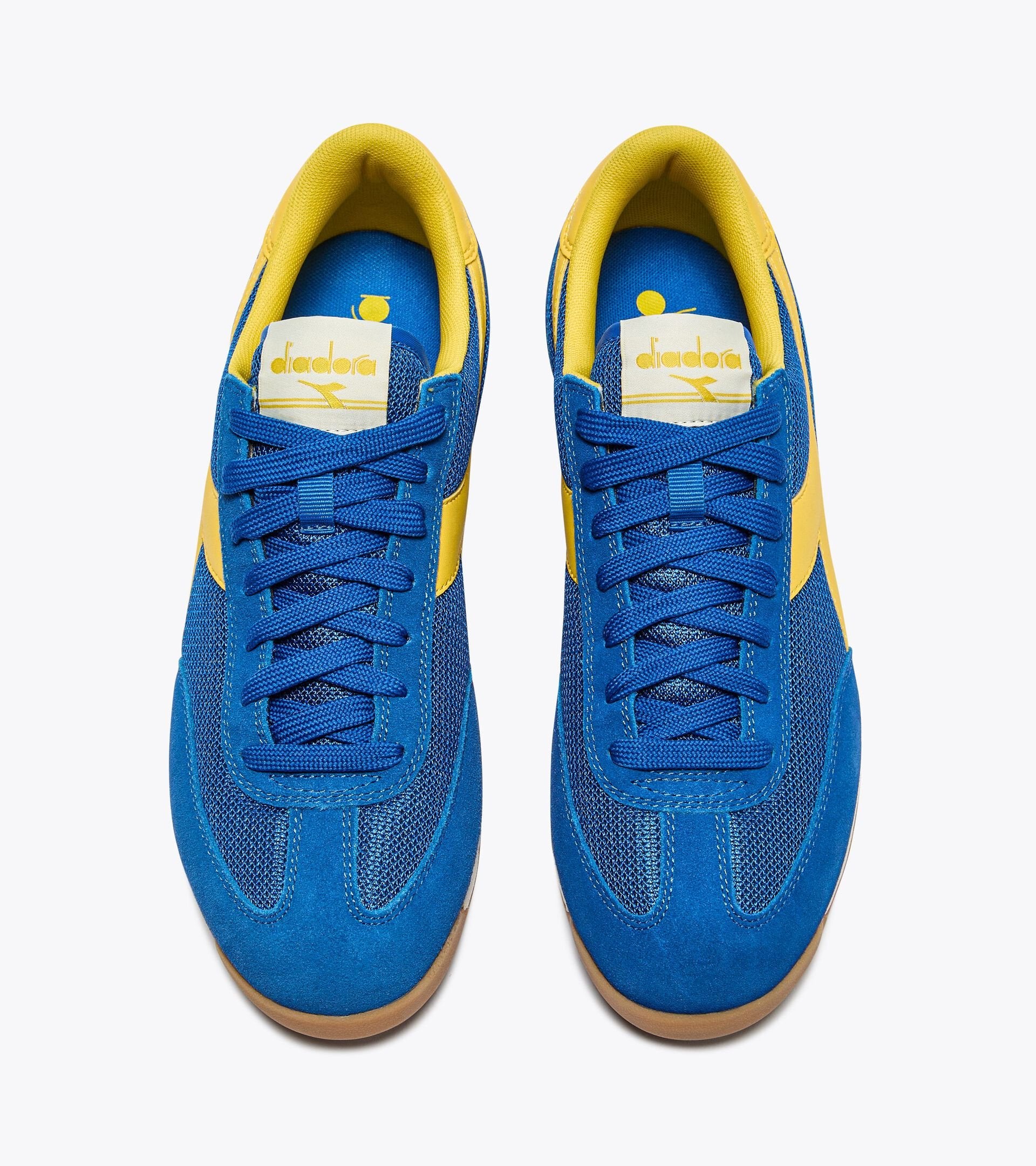 Vue supérieure des baskets Cross Diadora. Lacets plats, doublure jaune et forme rétro running.