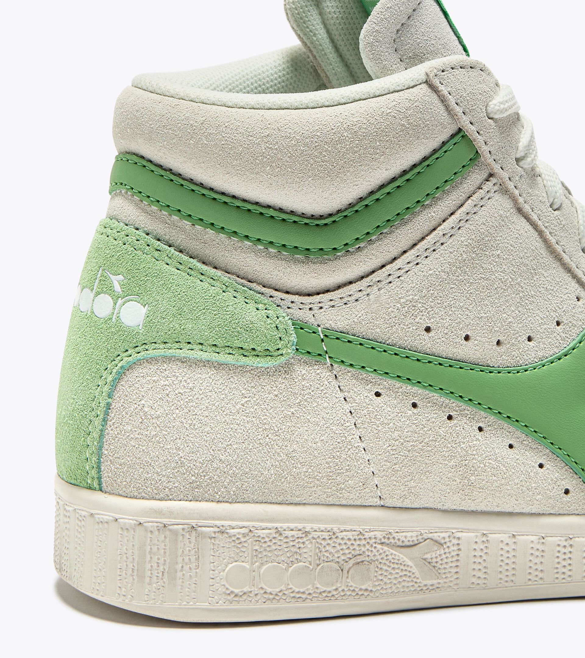 Détail du talon de la basket Game L Suede Diadora. Contrefort vert contrastant avec logo embossé.