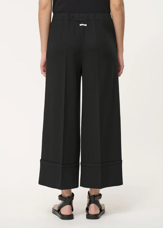 femme portant le pantalon large, modèle sophio en noir de la marque humility, vue de dos