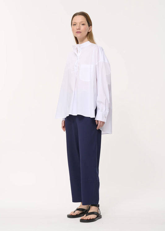 femme portant le pantalon unia de chez humility en bleu marine, porté de côté 